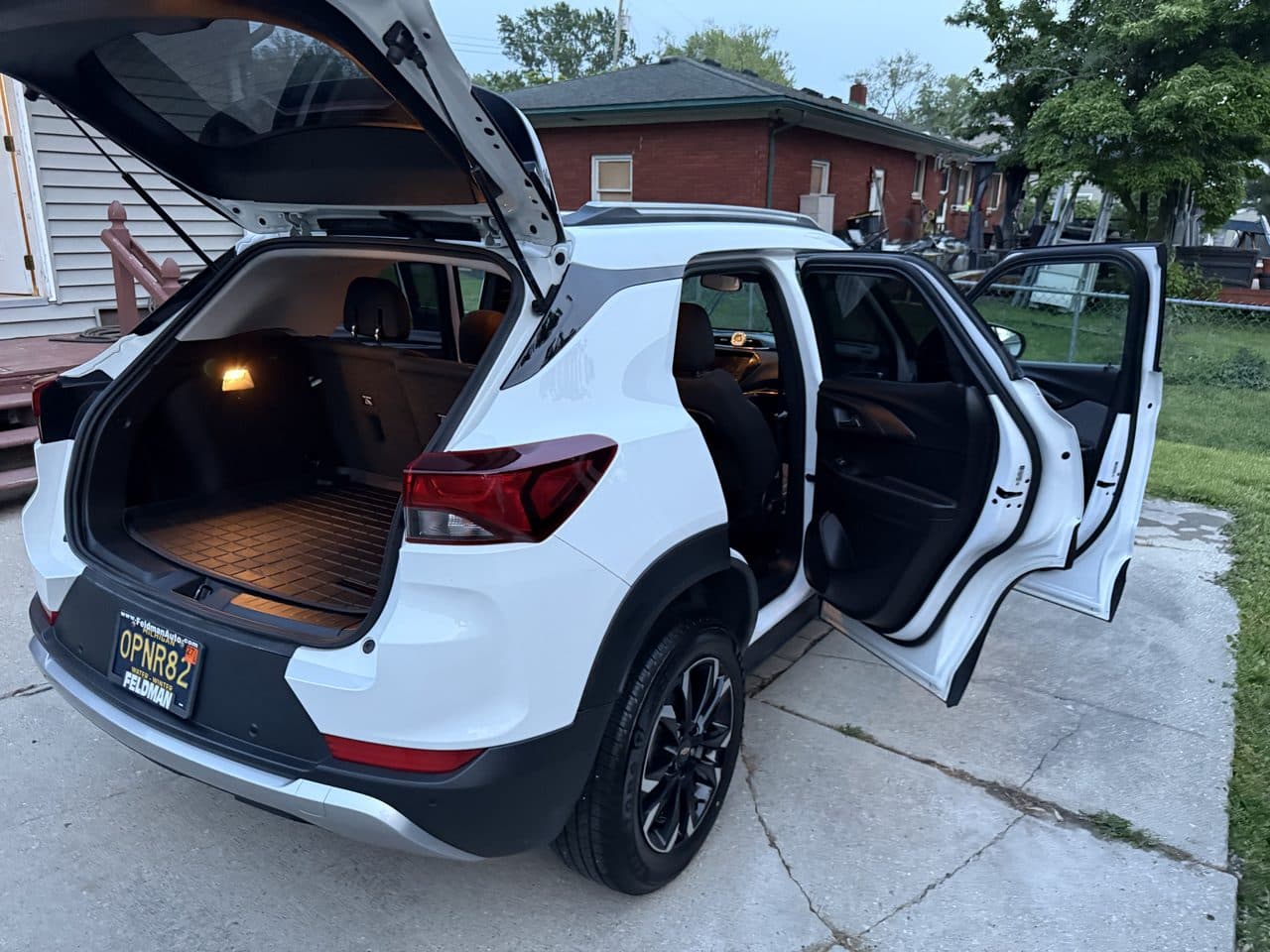 A white Chevrolet Trailblazer with the hatch and doors open during a detail